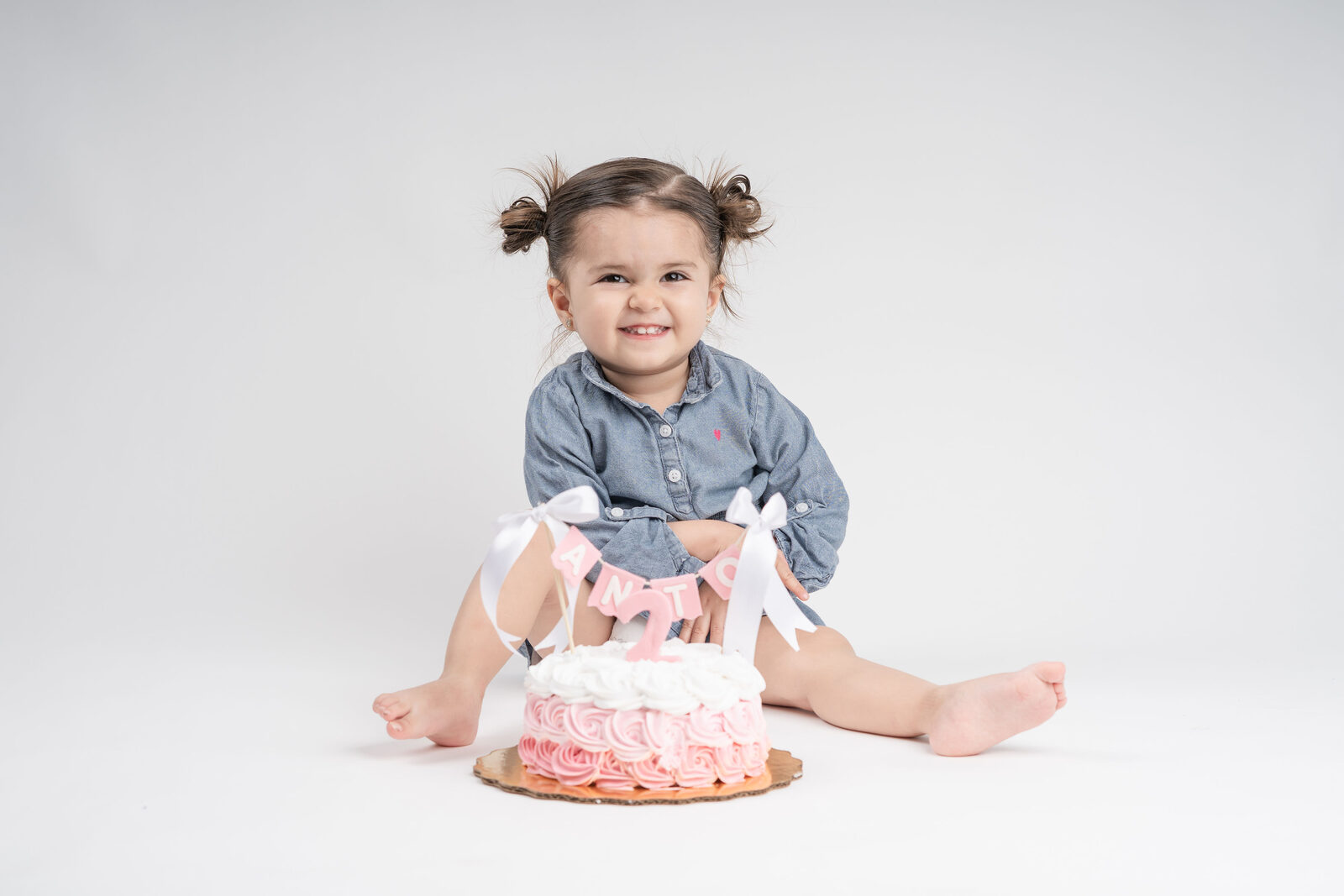 Bebé feliz aplastando su pastel en una sesión de smash cake