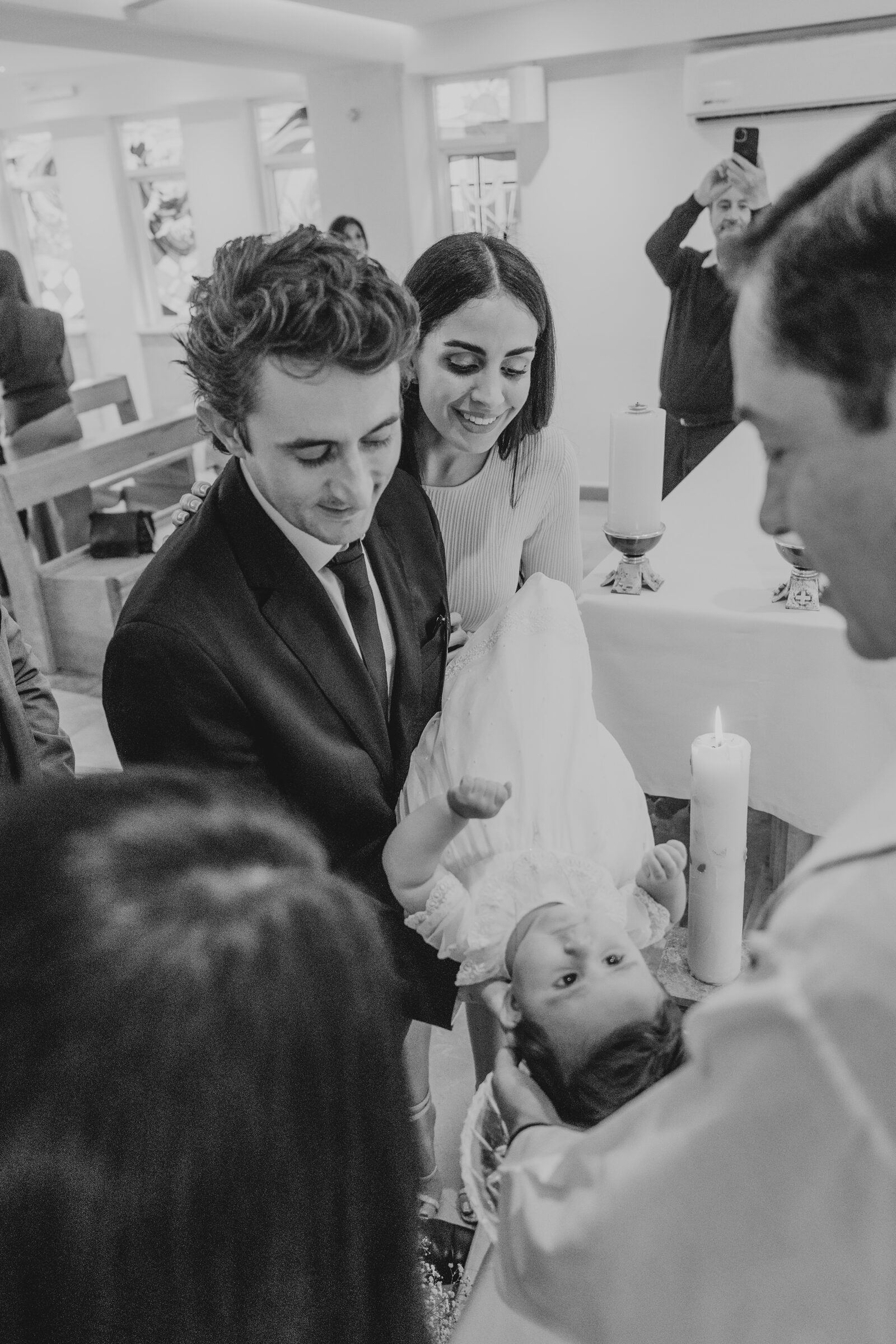 Bebé en el momento de su bautizo, en brazos de sus papás
